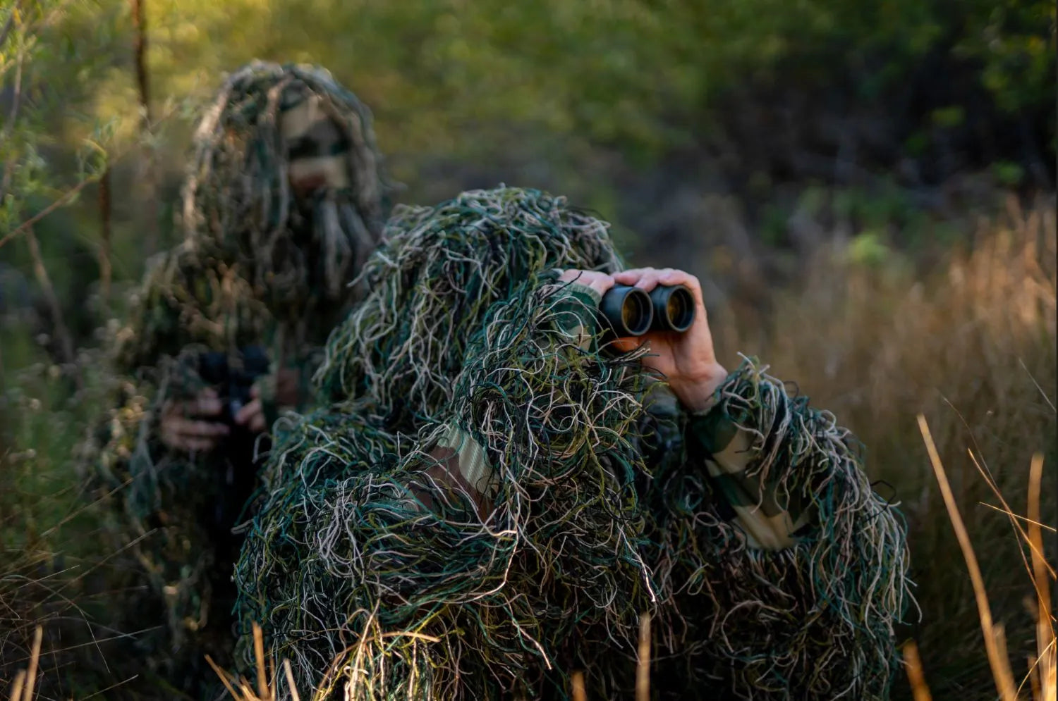 Two people in Arcturus Ultra-lite ghillie suits blending into nature.