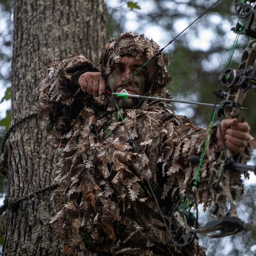Person wearing Arcturus Realtree EDGE 3D Leafy Ghillie Suit shooting a bow in a tree stand